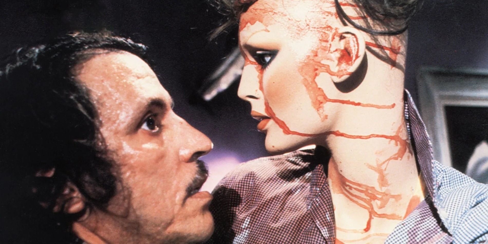 A profile shot of Frank, played by actor Joe Spinell, looking up at a blood-soaked mannequin in Maniac.