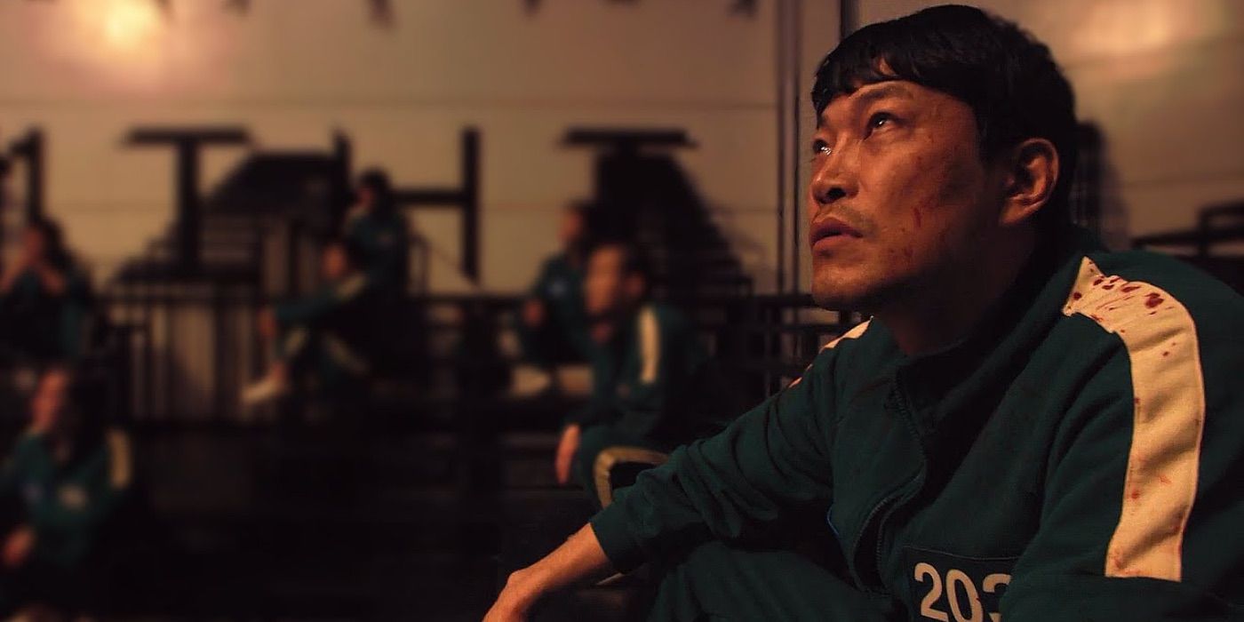 Gi Min looks up whilst sat on his bed in Squid Game.