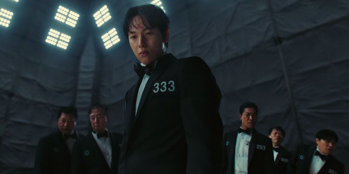 Myung-gi looks over the cliff's edge with the other finalists behind him in Squid Game.