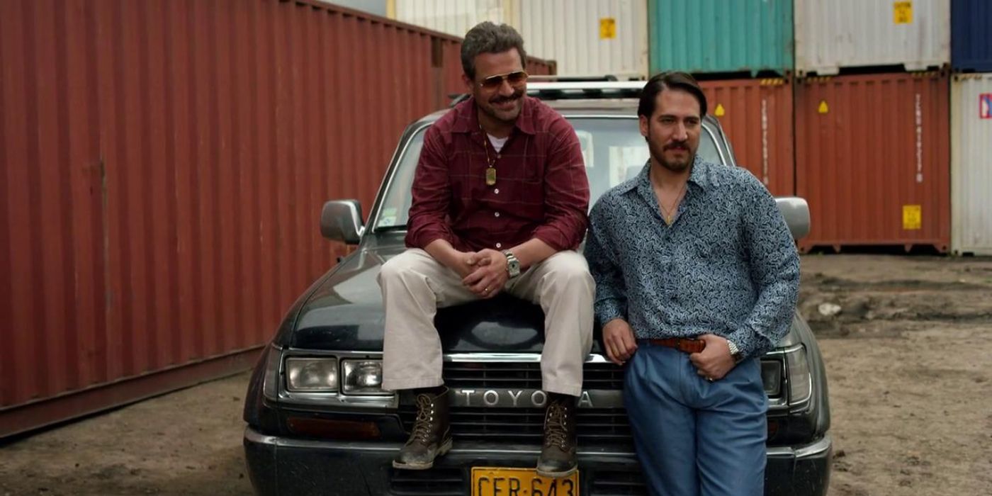 Pêpê Rapazote sitting on a vintage car and Alberto Ammann leaning on it in Narcos, "Sin Salida"