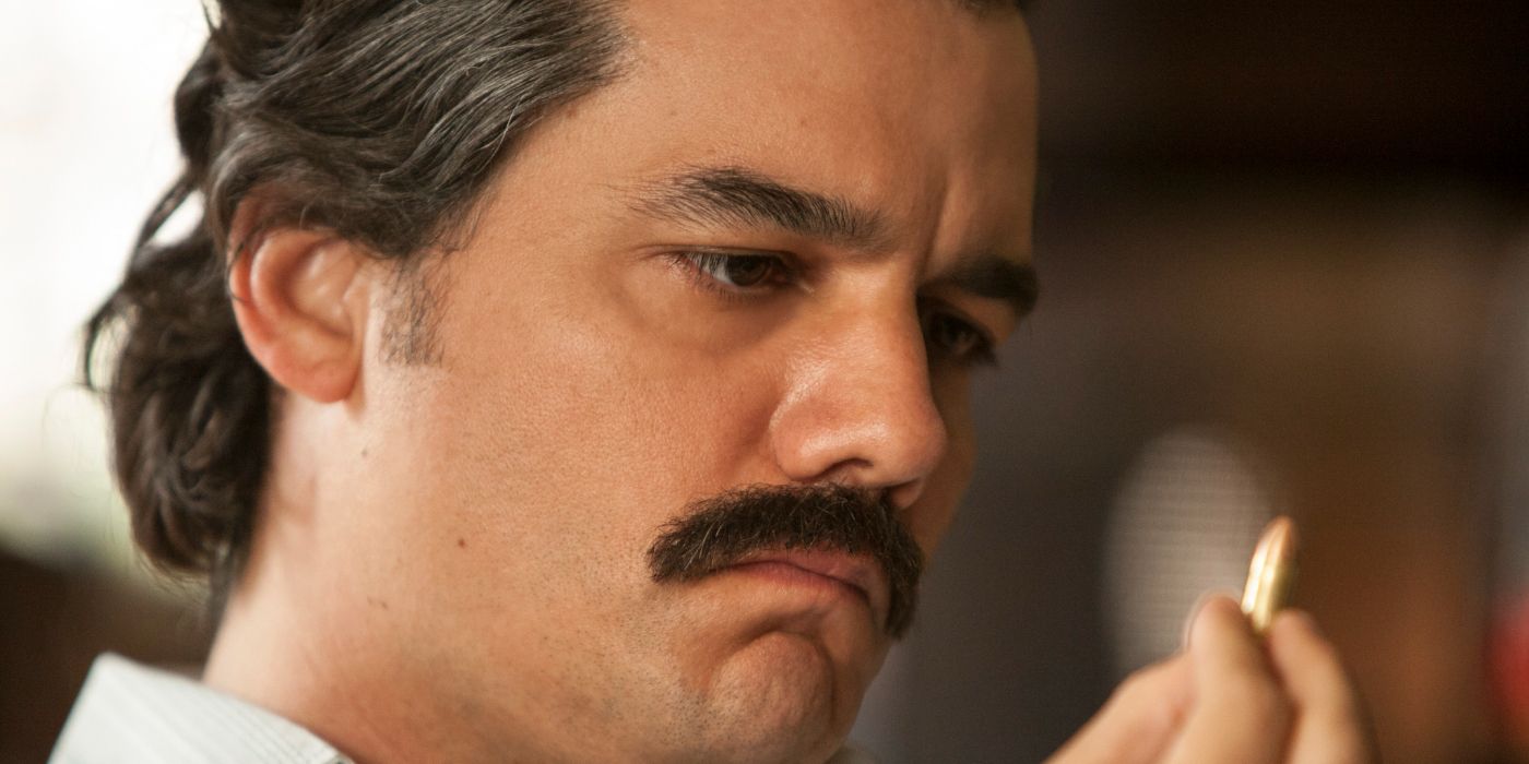 Wagner Moura in a tight closeup, looking closely at a bullet in Narcos, "The Good, the Bad, and the dead"