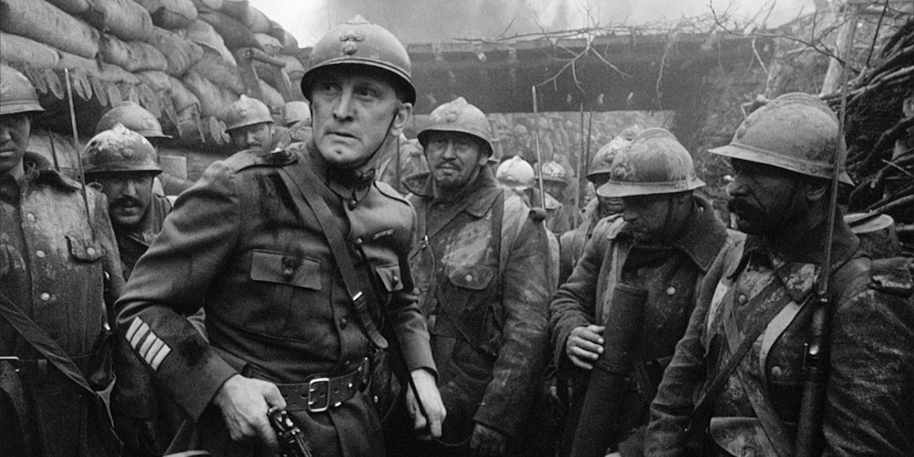 Kirk Douglas holding a gun while standing in a trench near the beginning of Paths of Glory (1957)