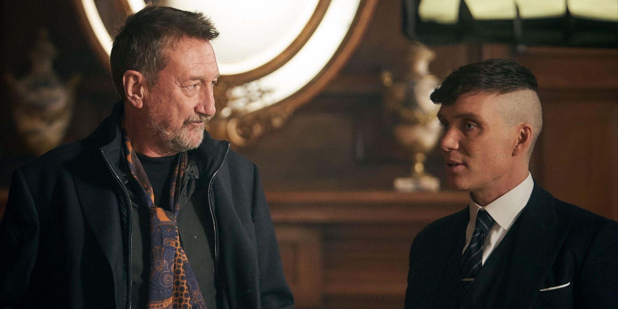 Steven Knight standing in front of Cillian Murphy and having a conversation on the set of Peaky Blinders