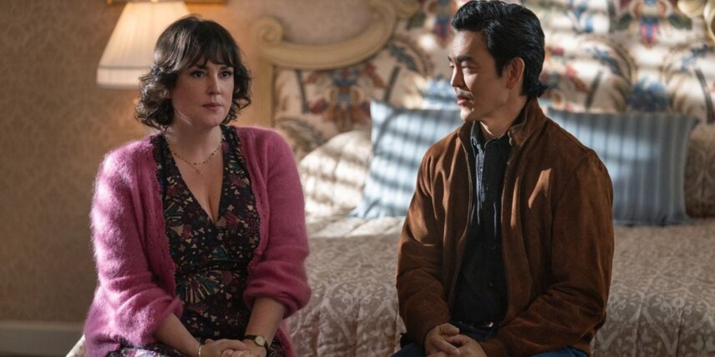 Melanie Lynskey as Regina Gilvary and John Cho as Guy sit at the edge of a bed in 'Poker Face' Season 2.