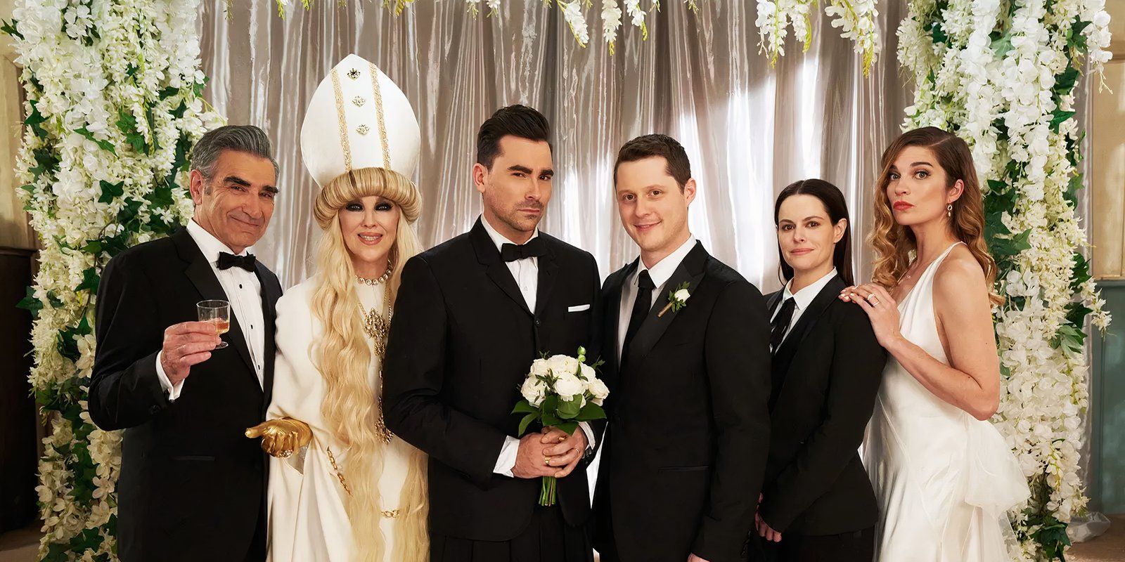 Schitt's Creek's cast of characters posing fiercely at a wedding.