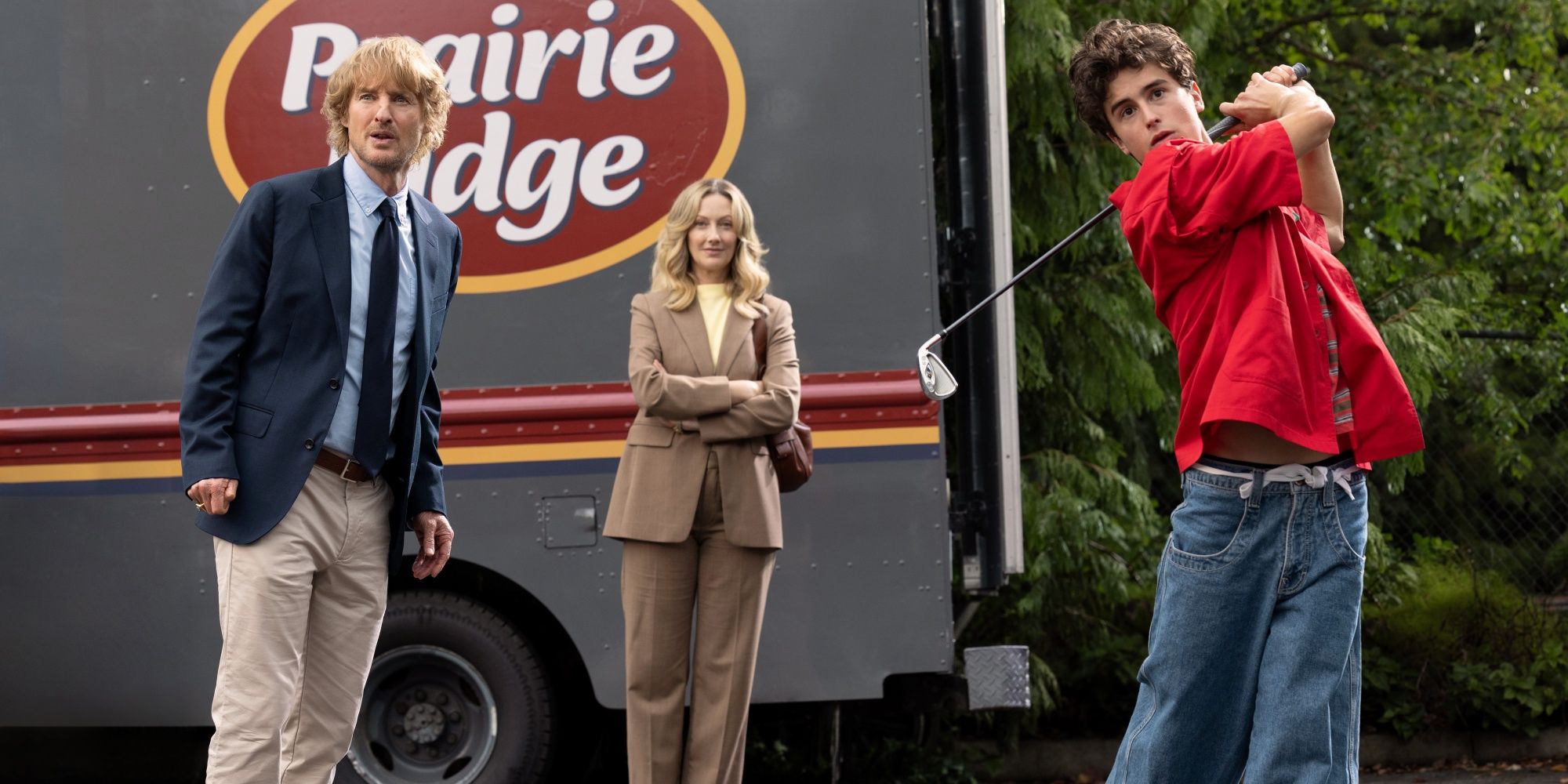 Owen Wilson as Pryce and Judy Greer as Amber-Linn watching Peter Dager as Santi swing his golf club in Stick