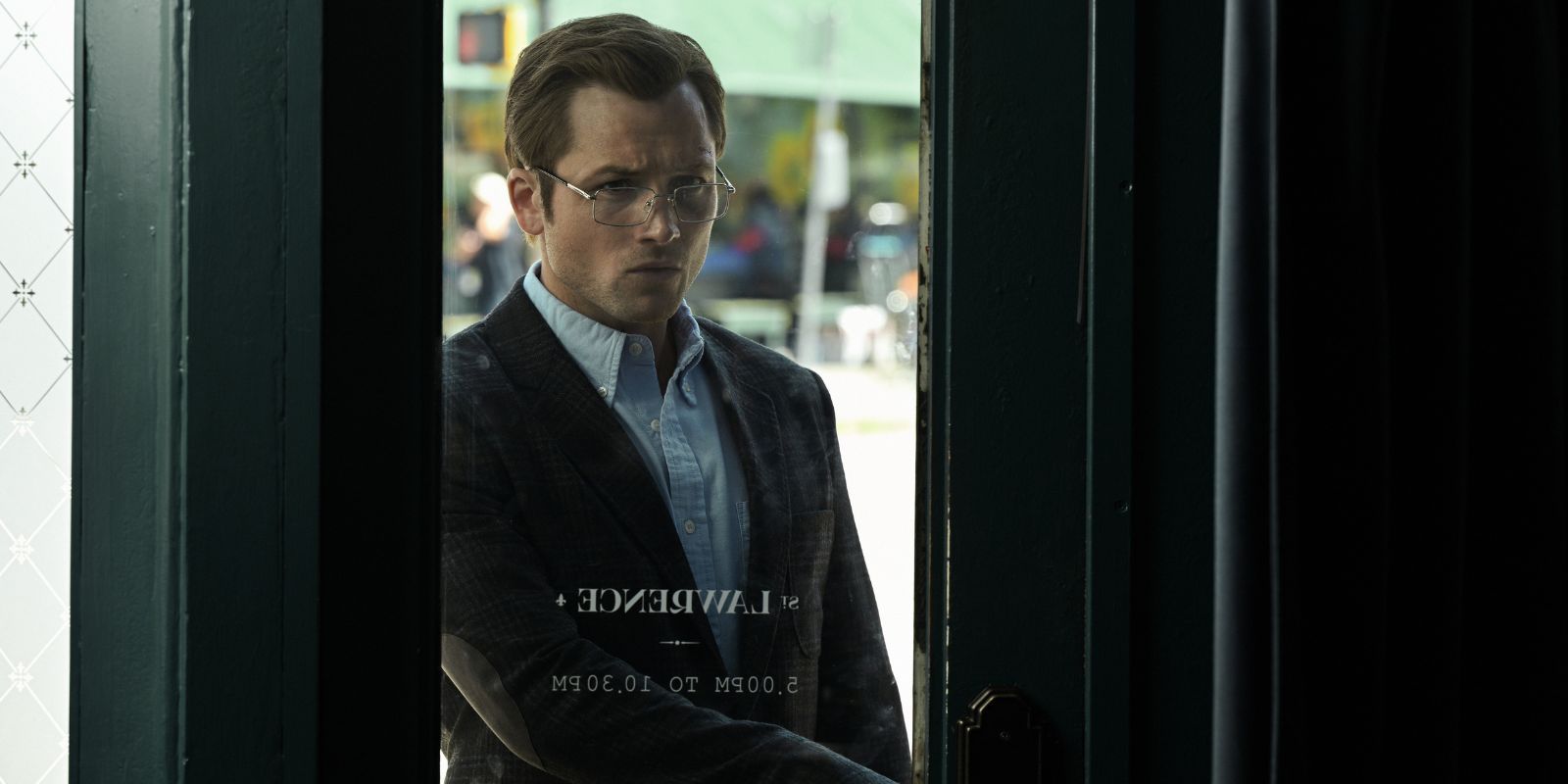 Taron Egerton about to enter a restaurant in Smoke