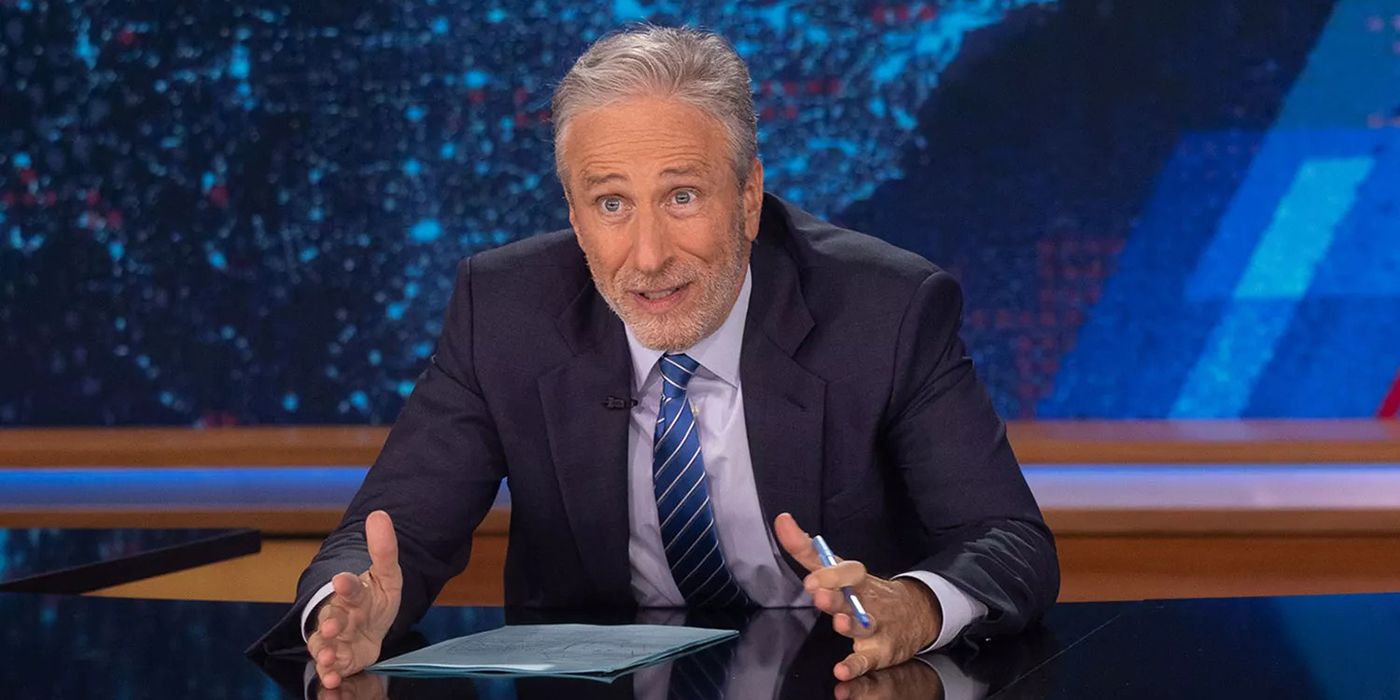 Jon Stewart, com as mãos, conversando animadamente no Daily Show.