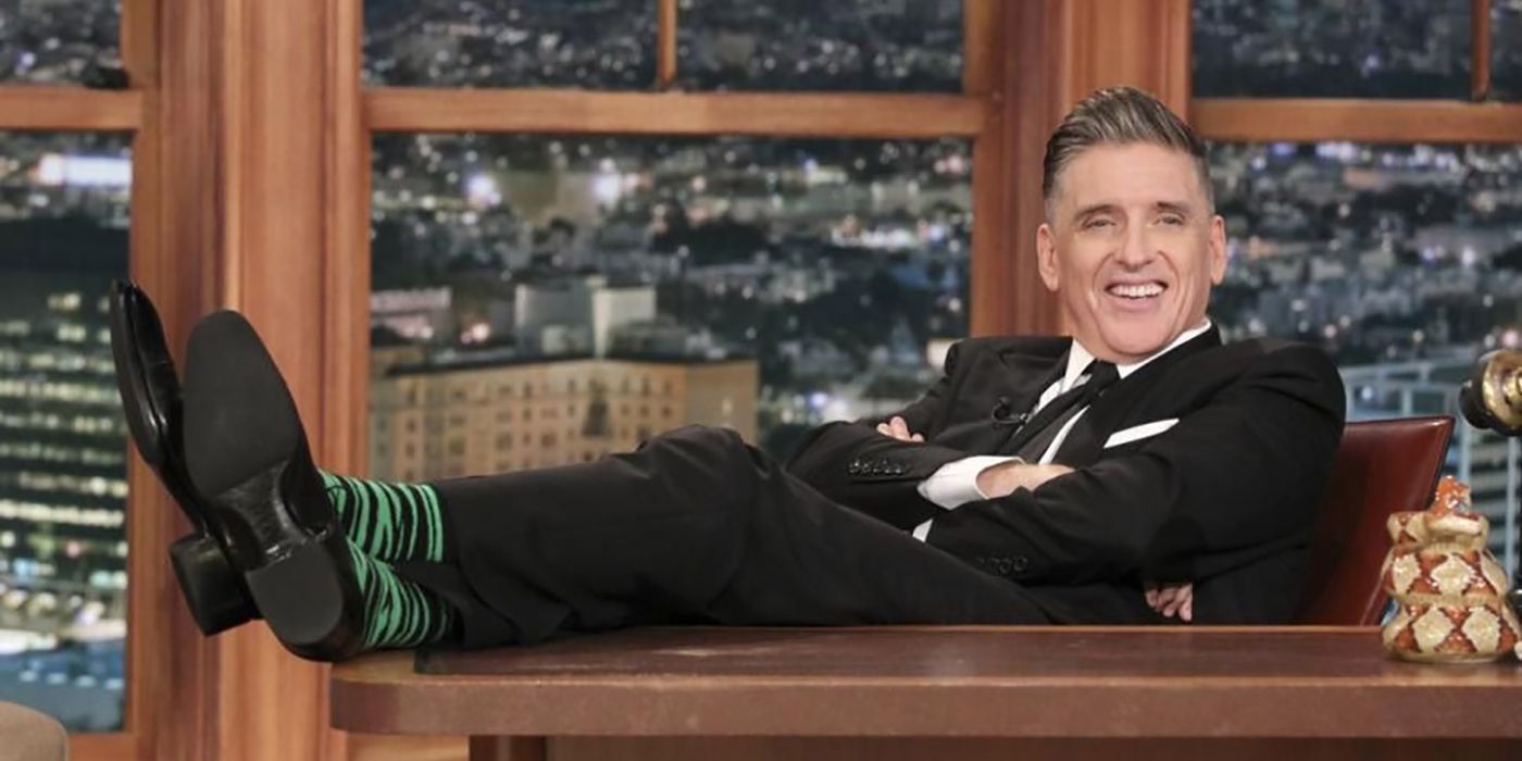 Craig Ferguson sentado atrás de sua mesa, pernas na mesa no final do Late Show com Craig Ferguson.