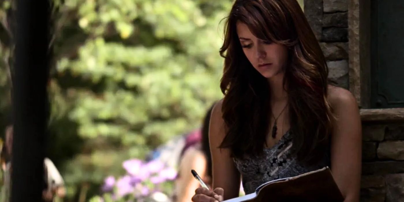 Nina Dobrev as Elena Gilbert writing in her diary in The Vampire Diaries.