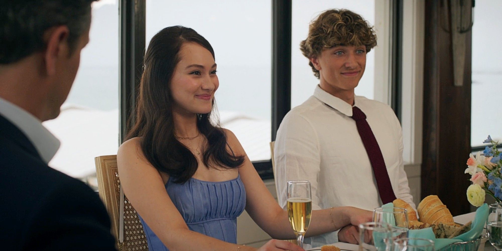 Belly Conklin and Jeremiah Fisher sitting next to each other and smiling at lunch in The Summer I Turned Pretty TSITP Season 3