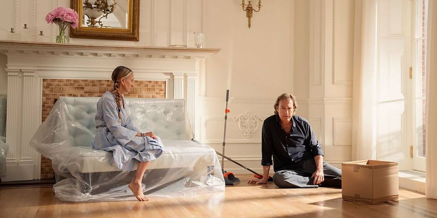 Carrie sitting on her bed, Aidan on the floor looking sad in And Just Like That...