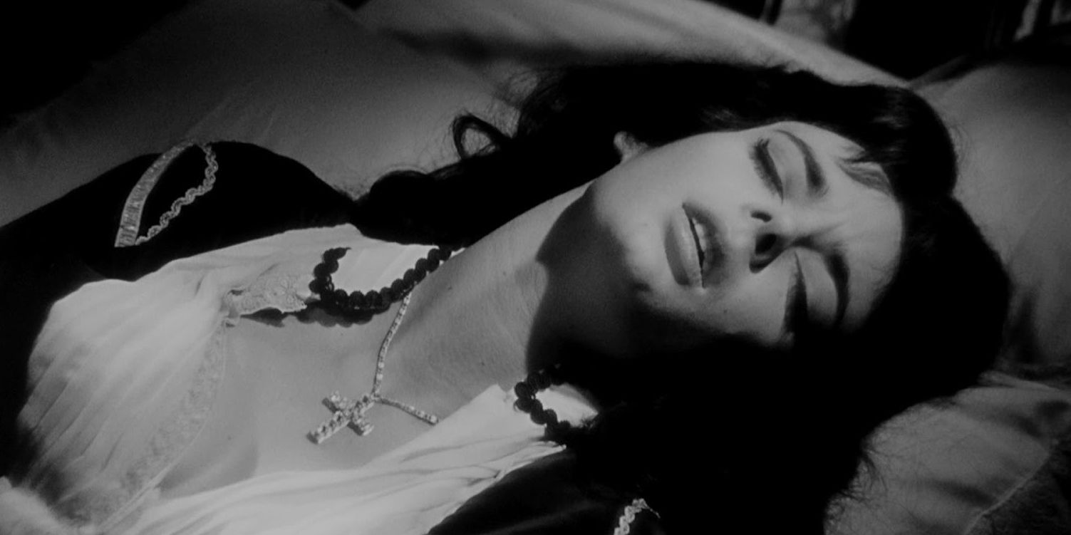 Barbara Steele as Katia lies on the bed with her eyes closed and her mouth slightly open in Black Sunday
