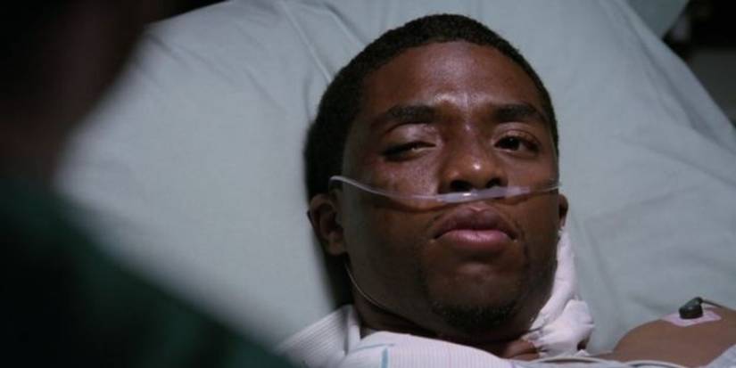 Derek (Chadwick Boseman) tries to talk to his father, but one eye is swollen shut.