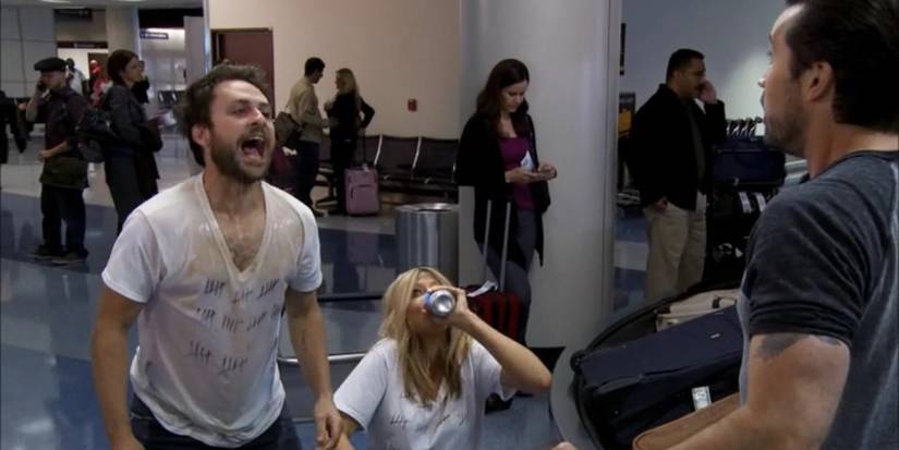 Charlie wearing a wet t-shirt and yelling at Mac as Dee drinks a beer sitting down in IASIP Season 10, Episode 1