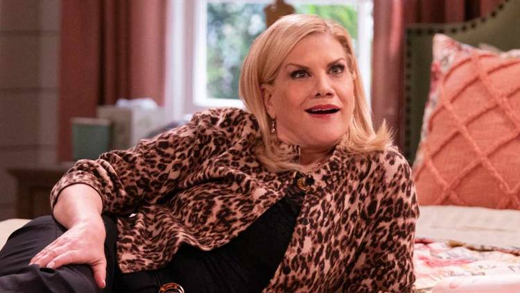 Kristen Johnston as Carol lounging on the bed in Leanne.