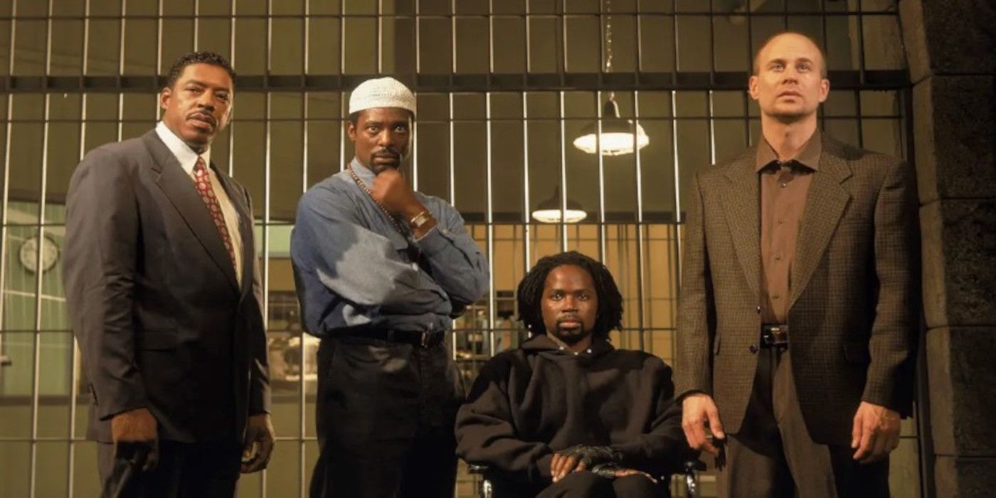 Warden Glynn, Kareem Said, Augustus Hill, and Tim McManus stand in front of prison bars in Oz.