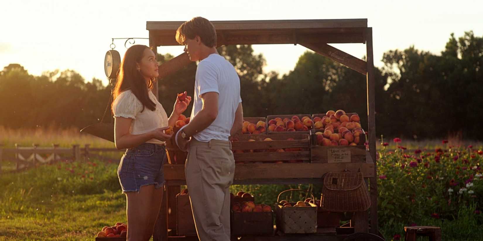 Belly Conklin and Conrad Fisher standing in front of a peach stand in The Summer I Turned Pretty TSITP Season 3