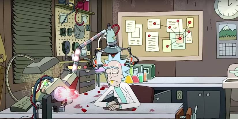 Rick sits sadly in the garage with a ray gun on his head in Rick and Morty.