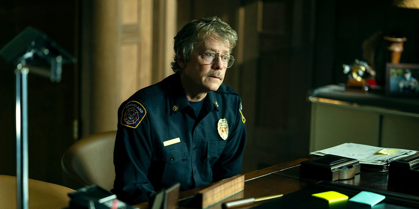 Greg Kinnear as Harvey sitting behind a desk and looking guilty in Episode 8 of Smoke