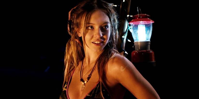 Sydney Sweeney smiling with a lantern on her back in Dead Ant