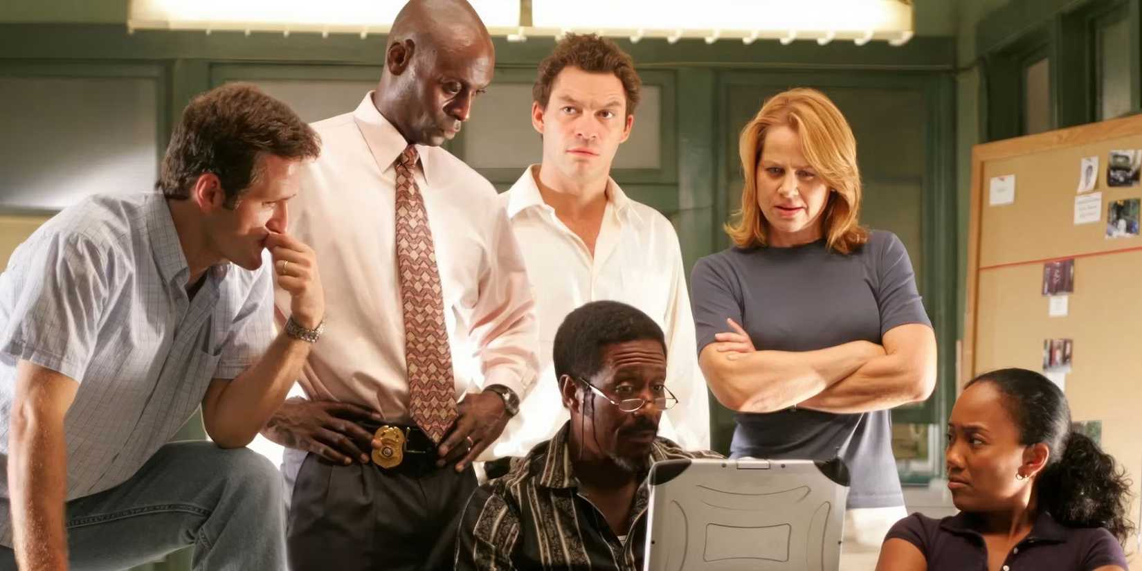 The cast of The Wire sits around a computer in the office.