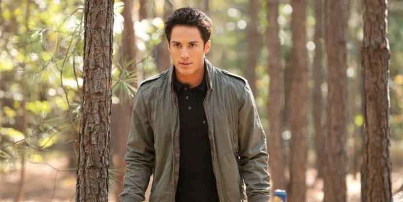 Michael Trevino as Tyler Lockwood walking through the woods during the day in The Vampire Diaries.
