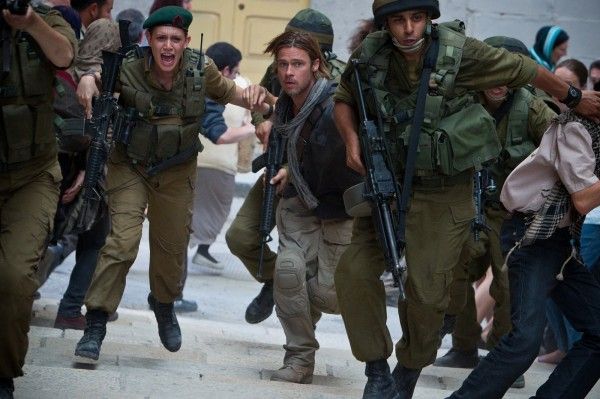 Gerry Lane, played by Brad Pitt, and Segen, played by Daniella Kertesz, run alongside soldiers as zombies overrun fortified Israel